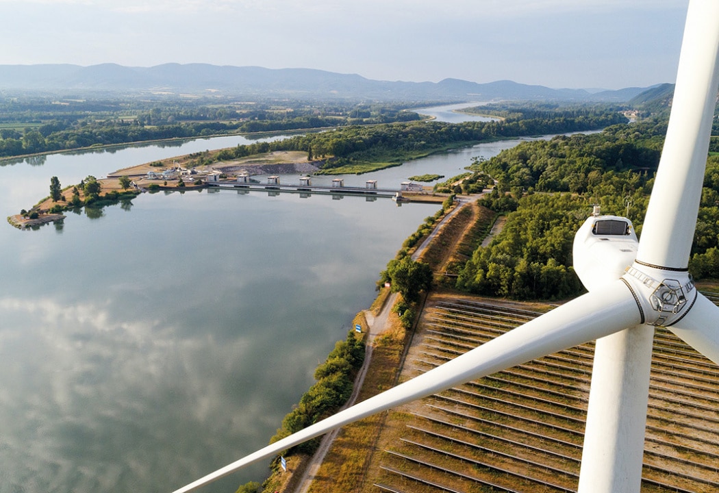 Vue dur le Rhône avec au premier plan une éolienne.